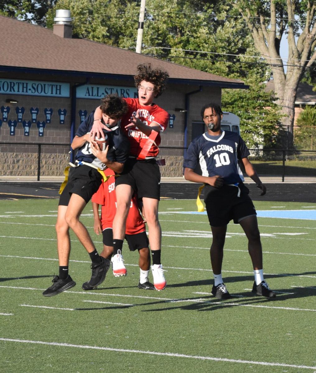Junior Harrison Scheidt jumps to catch the ball between two Falcon players. The ball was knocked out of the players hands.