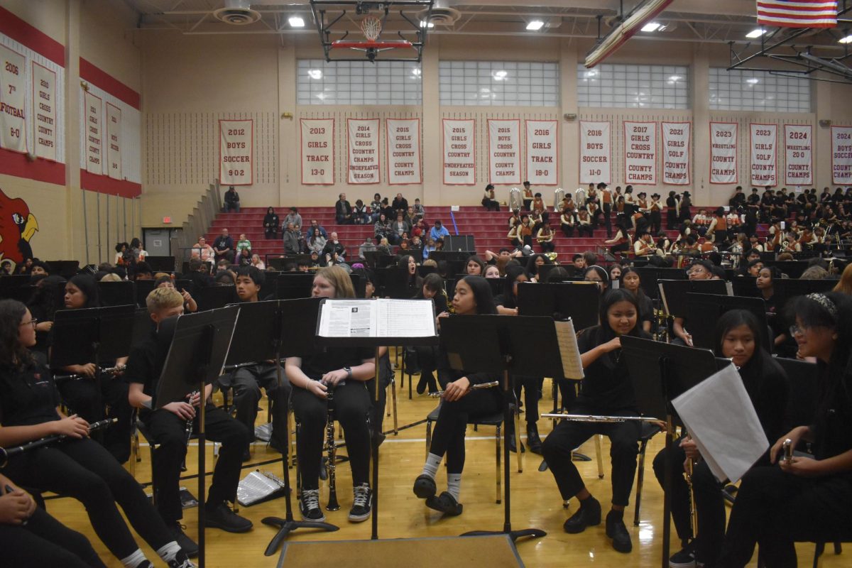 Seventh grade band kids wait for their teacher to come up to the podium and start the concert. They were seated 10 minutes before.