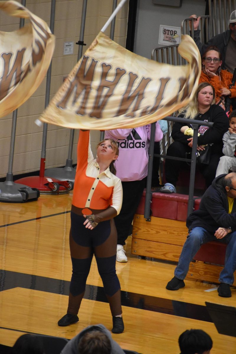 Freshman Sarah Trammell waits for her flag to fall into her hands after throwing it in the air. She caught the flag, and later, the color guard switched to prop guns.