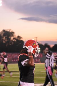 On Friday, Oct. 4, Senior JD Stanovic fixes his helmet as he walks to the sideline. The Cards won their last regular season game, 36-0 against Terre Haute South. This game would be Stanovic's final game of his high school career. 