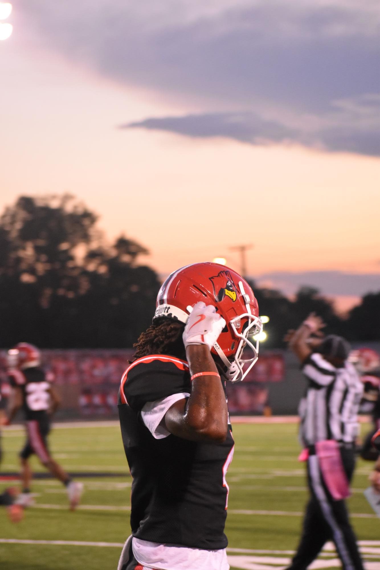On Friday, Oct. 4, Senior JD Stanovic fixes his helmet as he walks to the sideline. The Cards won their last regular season game, 36-0 against Terre Haute South. This game would be Stanovic's final game of his high school career. 