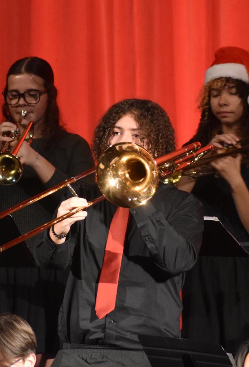 Junior Zachary Dyke plays the trombone during the performance. The orchestra played after the band finished.