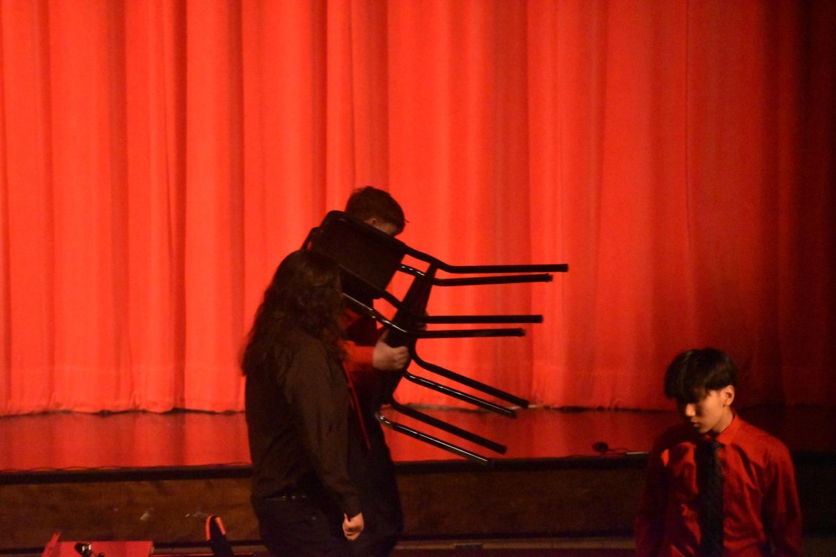 Students previously on stage clearing out their chairs and instruments to allow the choir to come on stage to perform. The choirs first song was "This Christmas" by Donny Hathaway.