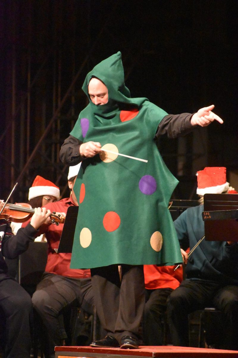 Orchestra director Thomas Wright conducts the right side of the stage as the rest of the orchestra continues to play. Wright then turned around and gave cues to the whole group as the music changed in speed.