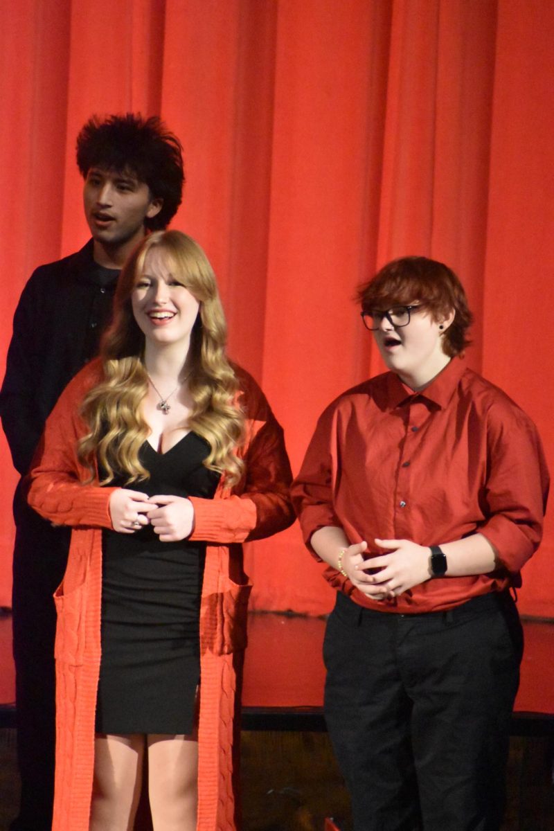 Sophomore Brooklyn Deckard and senior Alex Callaway stand together as they sing along to "T'was the Night before Christmas."