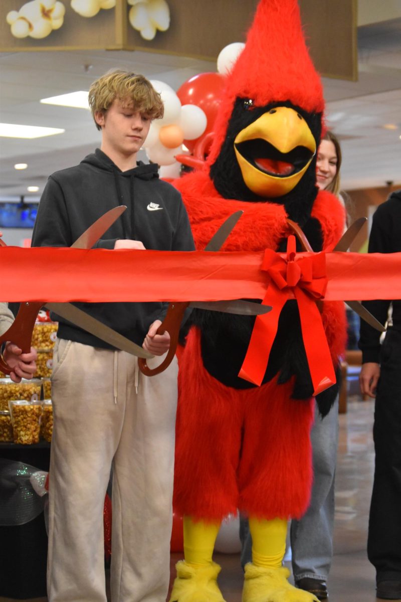 Junior Josiah Bryant and the Cardinal get ready to cut the ribbon to officially debut Cardinal Crunch at Kroger.