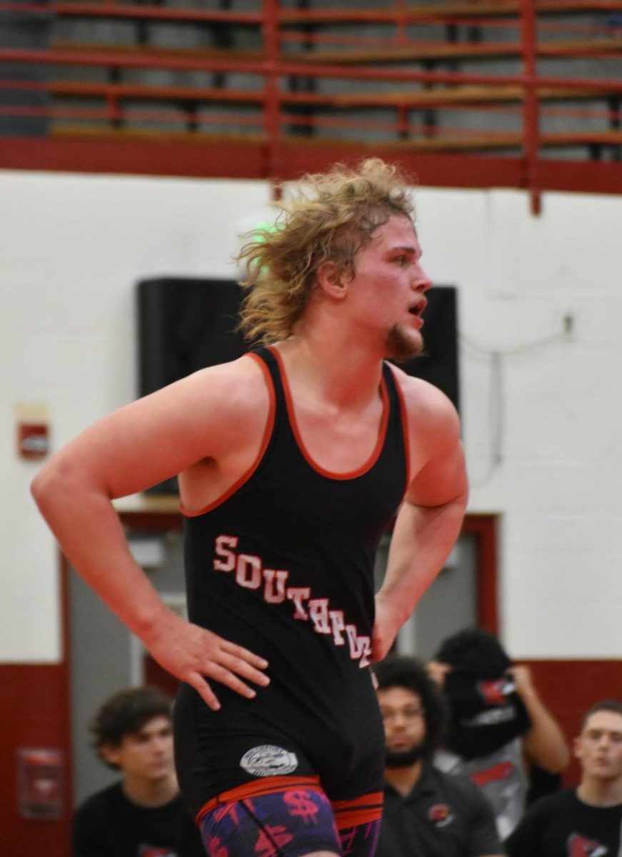 Senior Jayce Hancock finds his way off the mat after claiming victory over his opponent in the 215 lb. division. After three periods, Hancock scored two three-point takedowns and two escapes, tacking three points to the Cards' overall score.
