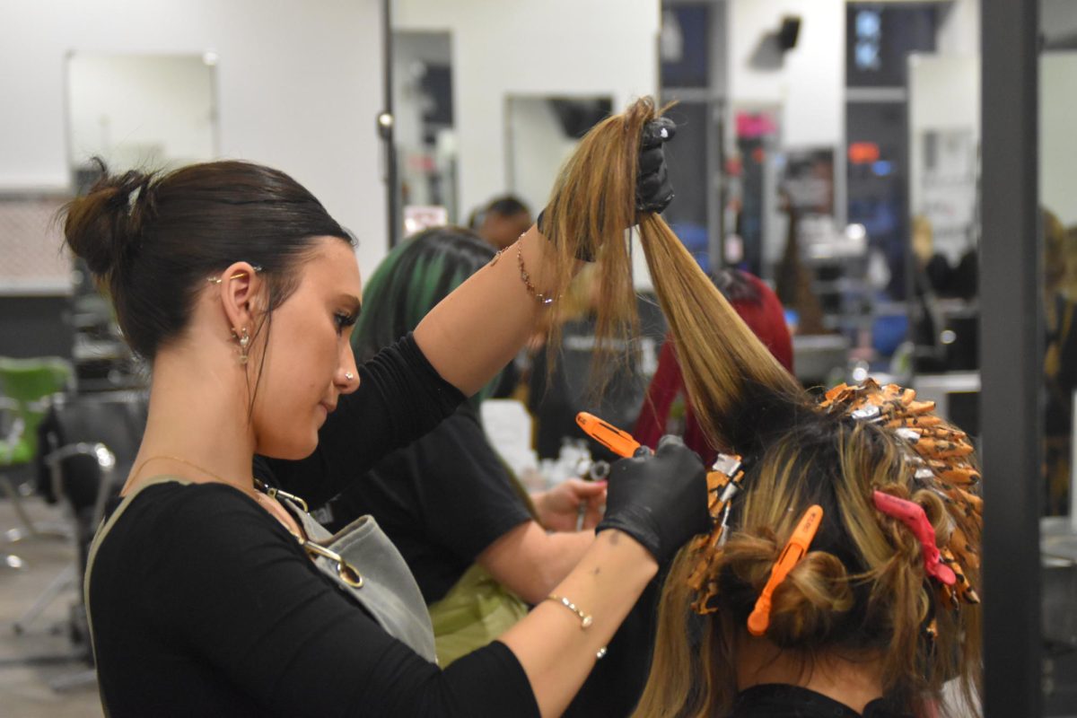 Senior Hayley Holland does her client, sophomore Penny Kautsky's hair at Paul Mitchell on Feb. 4. Holland has been enrolled at Paul Mitchell for 2 years and has learned how to do a vast array of hairstyles.