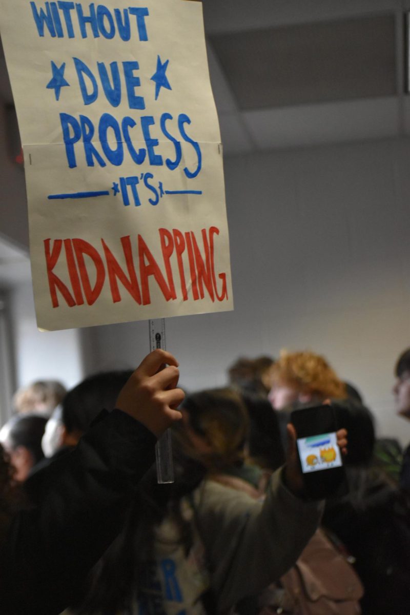 SHS students hold up their signs as they exit through the doors. Snow was blocking one of the doors so students had to rely on one exit. 