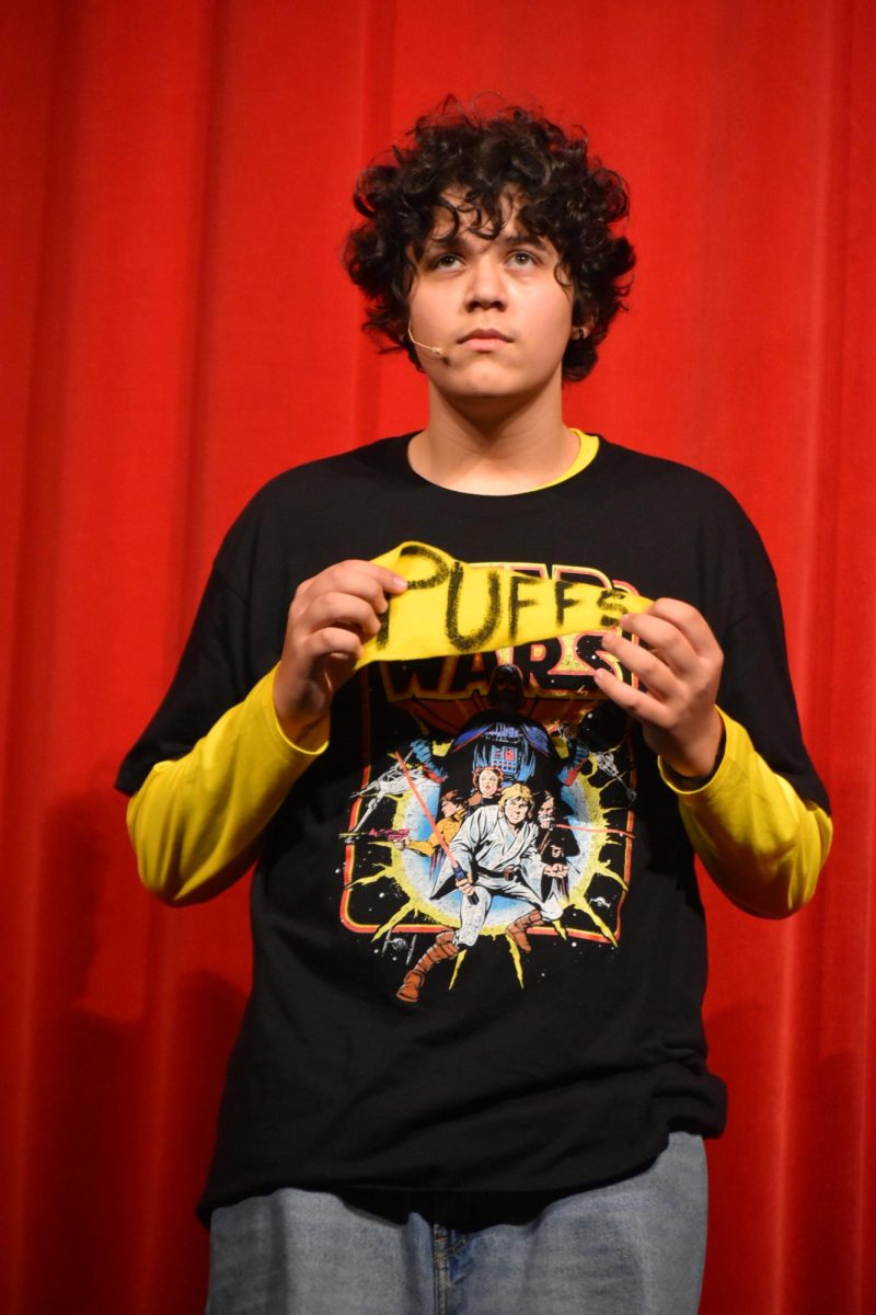 Freshman Elijah Beckham (Wayne Hopkins)
holds up a Puffs flag during the student matinee. He learned that after seven years of magic school, love is the only magic he needs.