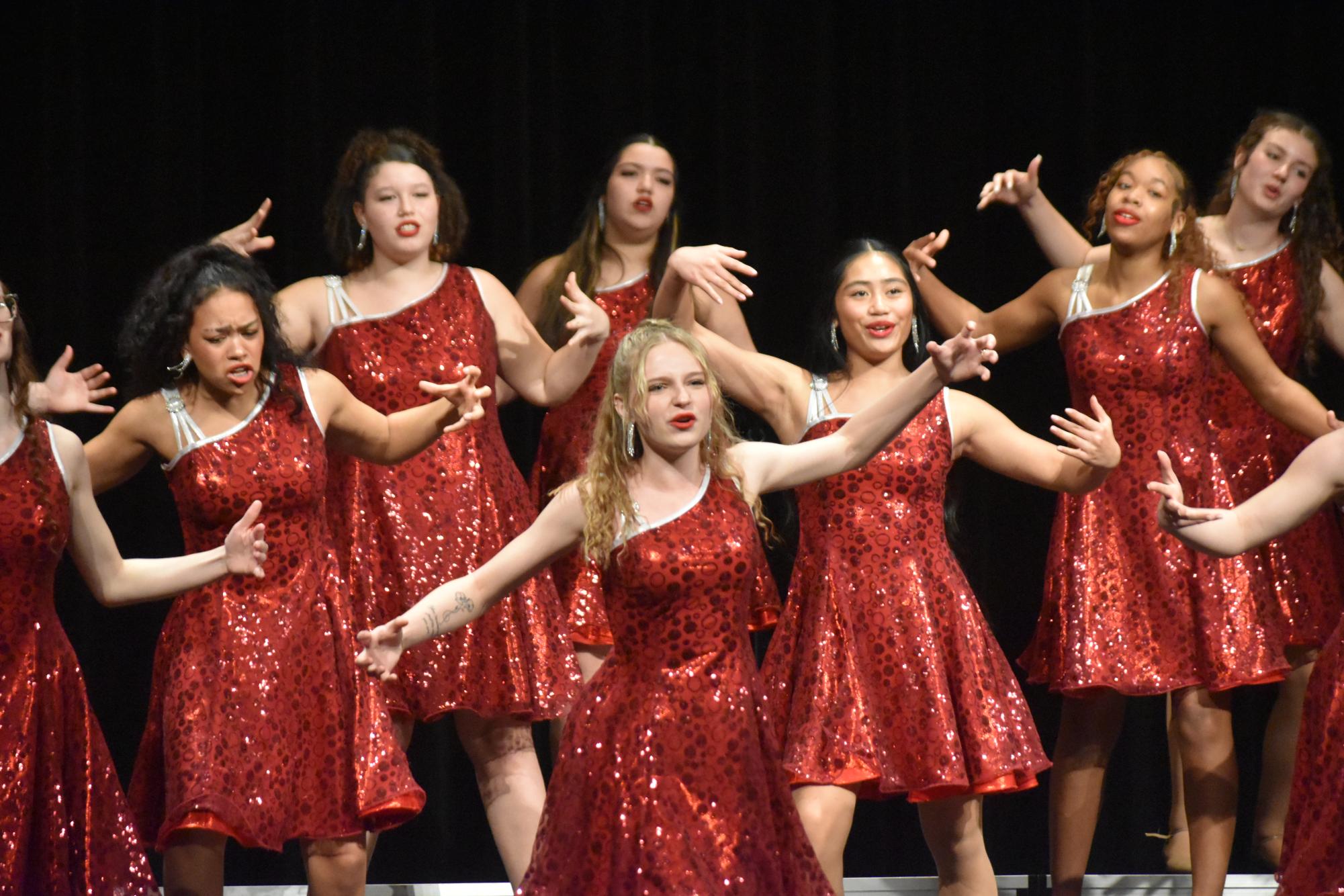 Senior Maddie Stutz widens her arms during show choir's performance of "Perfect Illusion."