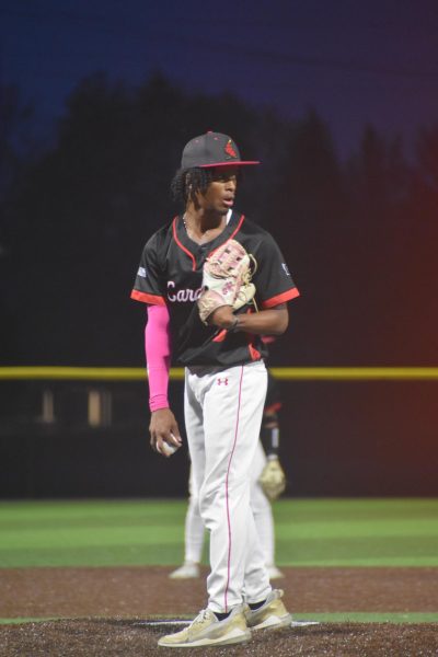 Senior TJ Duncan checks the runner at first base before delivering the next pitch. 