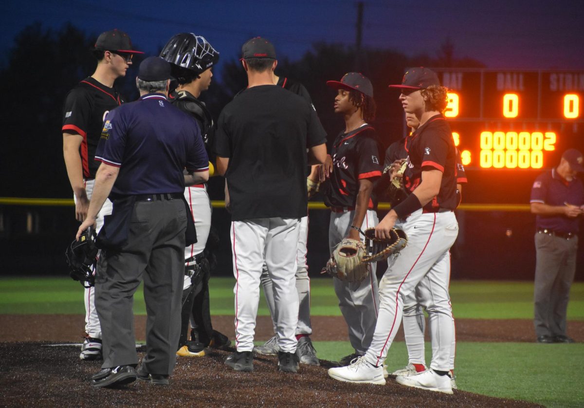 The cards infield and head coach huddle on the mound at the top of the sixth inning. 