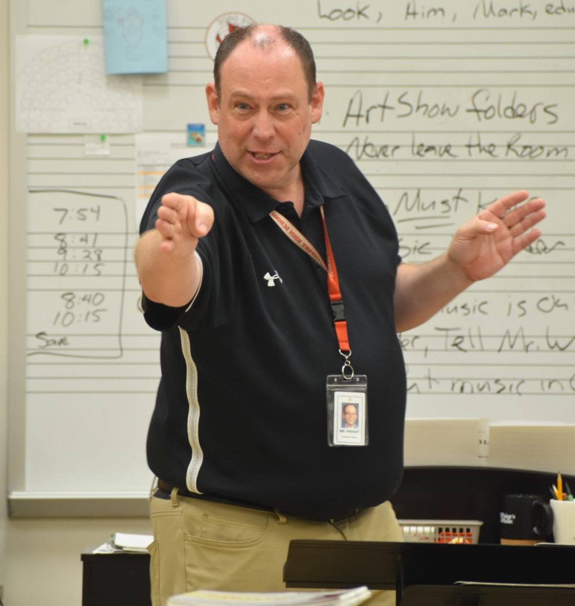 Wright conducted his intermediate orchestra. He cued the Violias when to enter the song. 