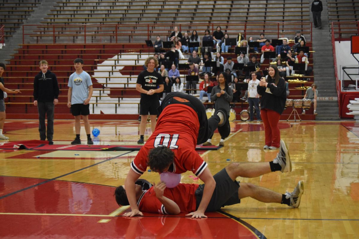 Senior Gabe Harman and senior Miles Caudil work together to pop their balloons in the balloon-popping contest. They used their chests as a tool.