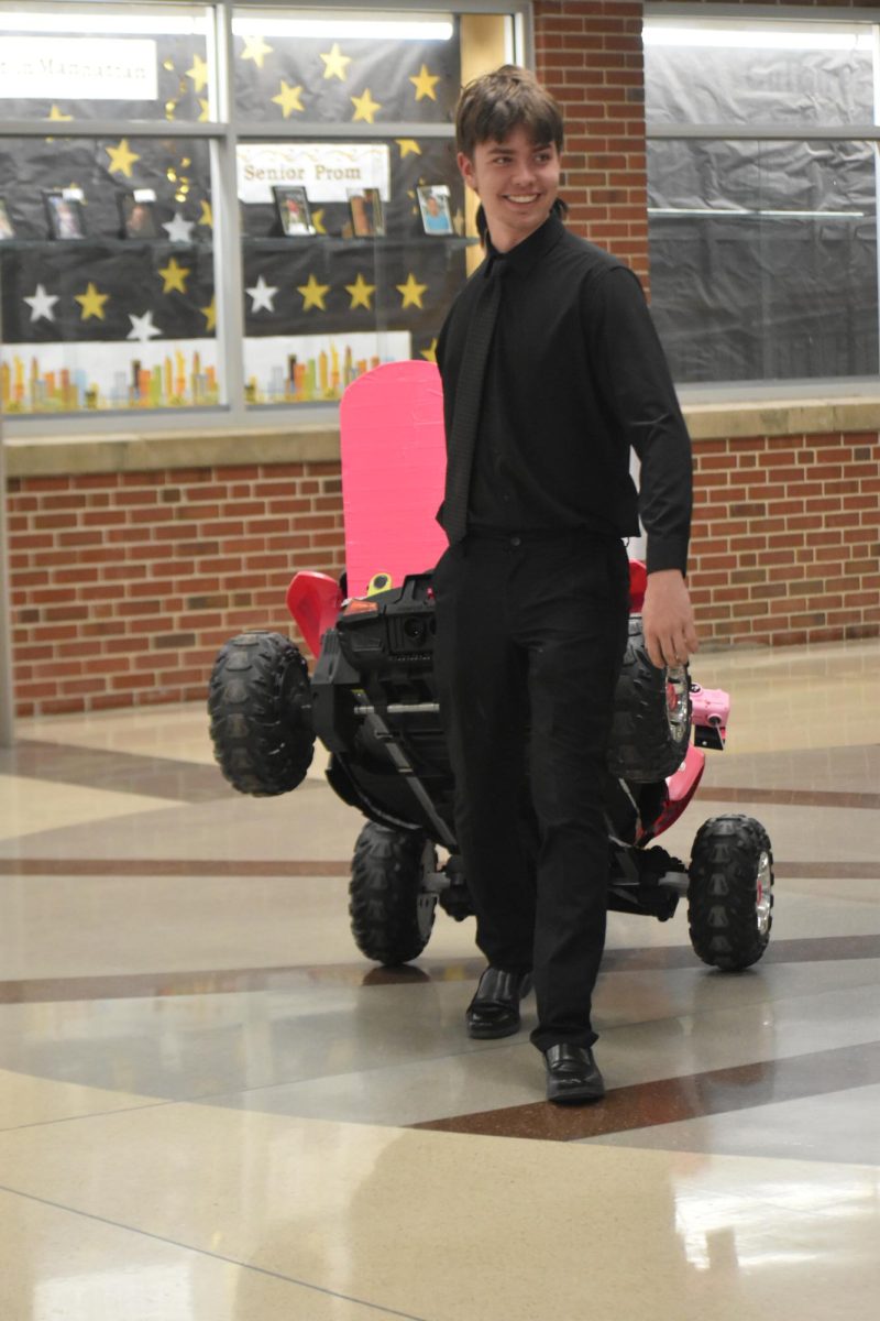 Sophomore Hunter Gaynor carries a car one of the students worked on. It was set up by all of the other cars near the robotics trust.